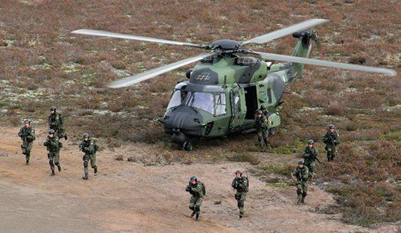 Soldater avancerar från en landad helikopter